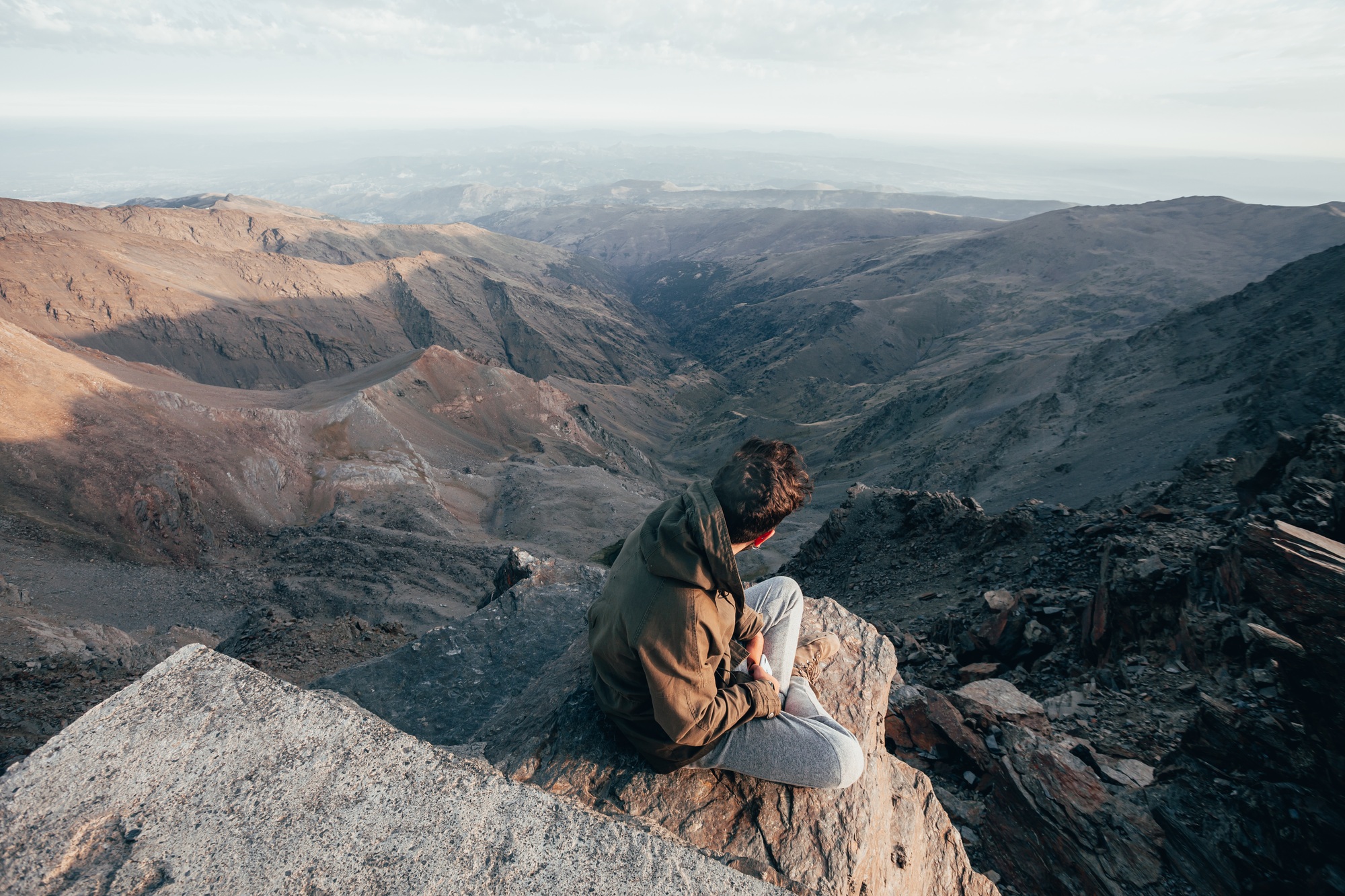 Hiker enjoying a beautiful landscape view from the summit of Mulhacen in Sierra Nevada, Spain